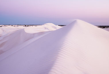 一望無際的潔白沙丘，被傍晚的暮色染上淡淡的紫