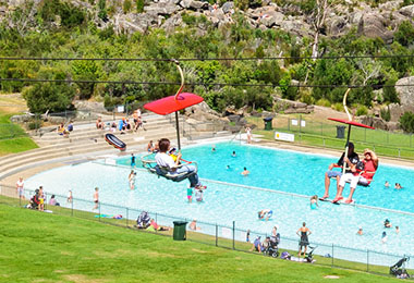 搭乘空中觀景纜車，下方可看到大型泳池和一堆草地上坐著聊天的人群